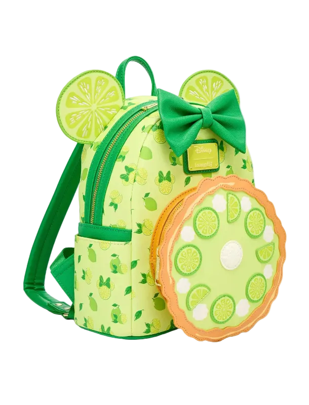 A lime-themed mini backpack with a matching round zippered pouch, featuring a green bow, mouse ears with lime slice designs, and a pie-crust-look border on the pouch, shown on a light gray background.