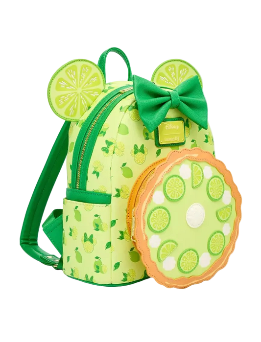 A lime-themed mini backpack with a matching round zippered pouch, featuring a green bow, mouse ears with lime slice designs, and a pie-crust-look border on the pouch, shown on a light gray background.