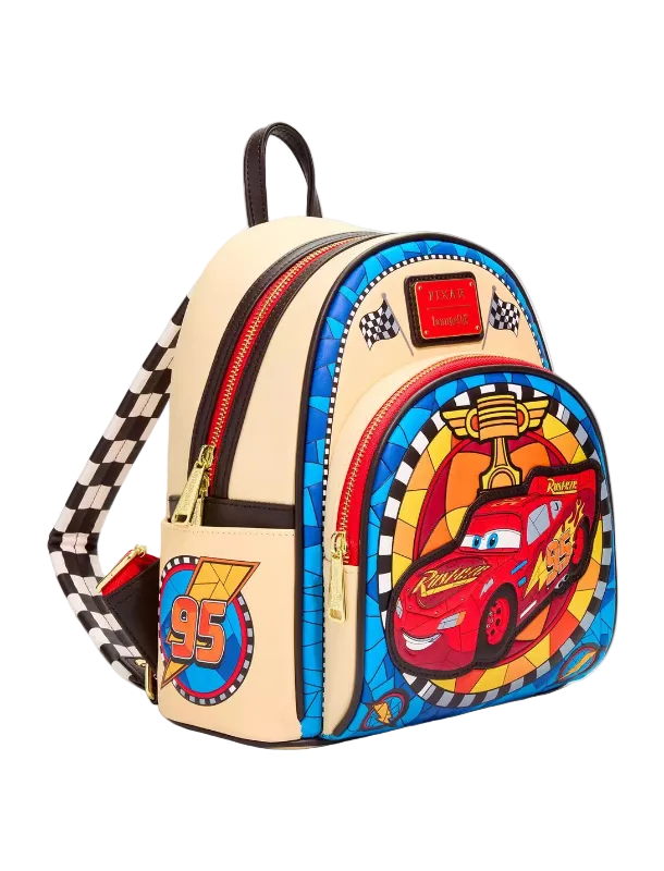A Disney Cars Lightning McQueen themed mini backpack on a light gray background. The backpack features a cream-colored body with a blue patterned front panel, a red Lightning McQueen graphic, gold zippers, and a checkered strap.