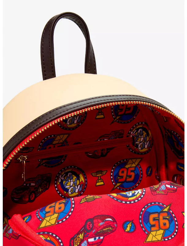 Close-up of a Disney Cars backpack showing the beige exterior top and the red interior printed with Lightning McQueen and other character graphics.