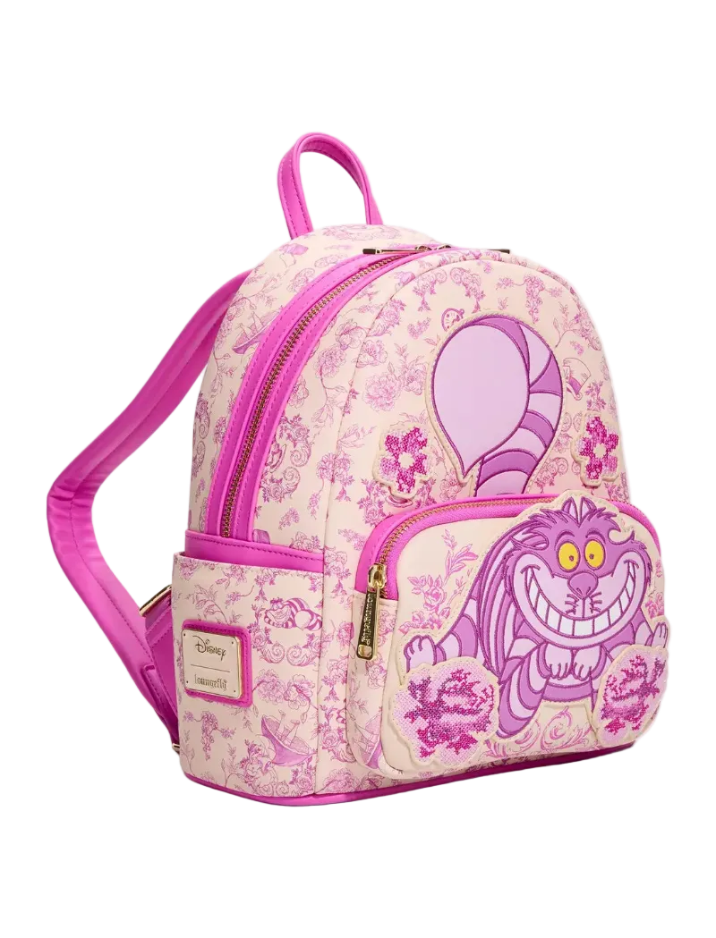 A pink and purple patterned mini backpack featuring a large Cheshire Cat graphic on the front pocket, with a Disney Lounge Series patch on the side pocket.