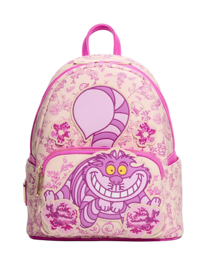 A pink and purple Disney Cheshire Cat backpack with a floral toile pattern, featuring a large Cheshire Cat graphic on the front pocket and a pink top handle, shown against a plain white background.