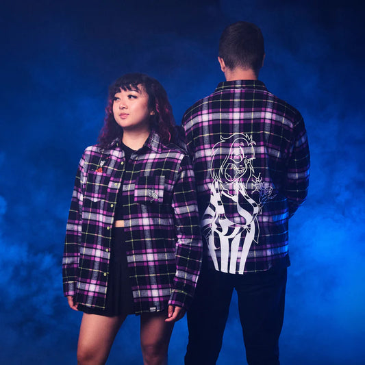 Two people wearing matching plaid shirts with a blue gradient background