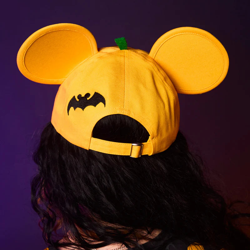 Yellow cap with bat design and pumpkin top on a dark background