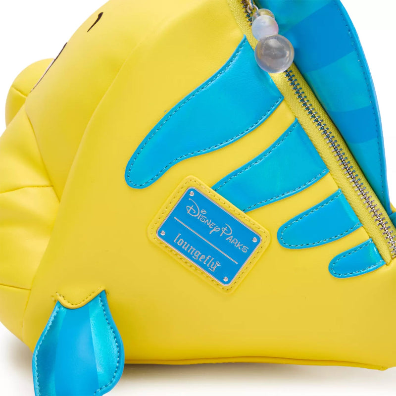 Close-up of a yellow and blue Disney Parks Loungefish zippered pouch bag, showing the brand patch and part of the fish's body.