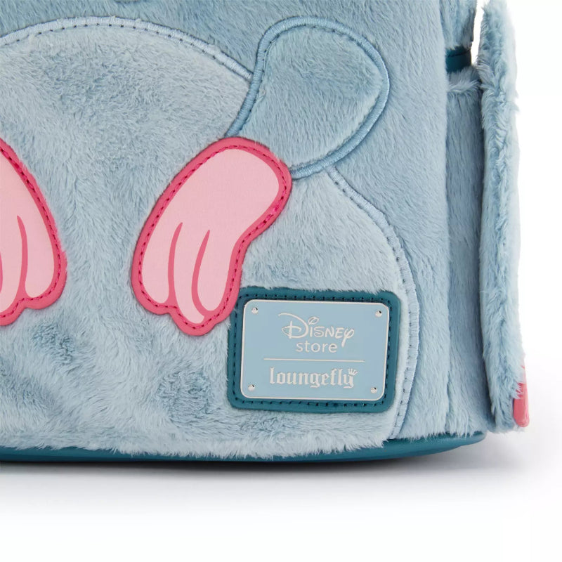 Close-up of a light blue plush Disney Store Loungefly bag with pink paw-shaped accents and a blue brand patch on a white background.