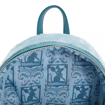 Close-up of the inside of a light blue plush backpack with a teal zipper and handle, featuring a repeating dark blue 'Le Ratatouille' character print.