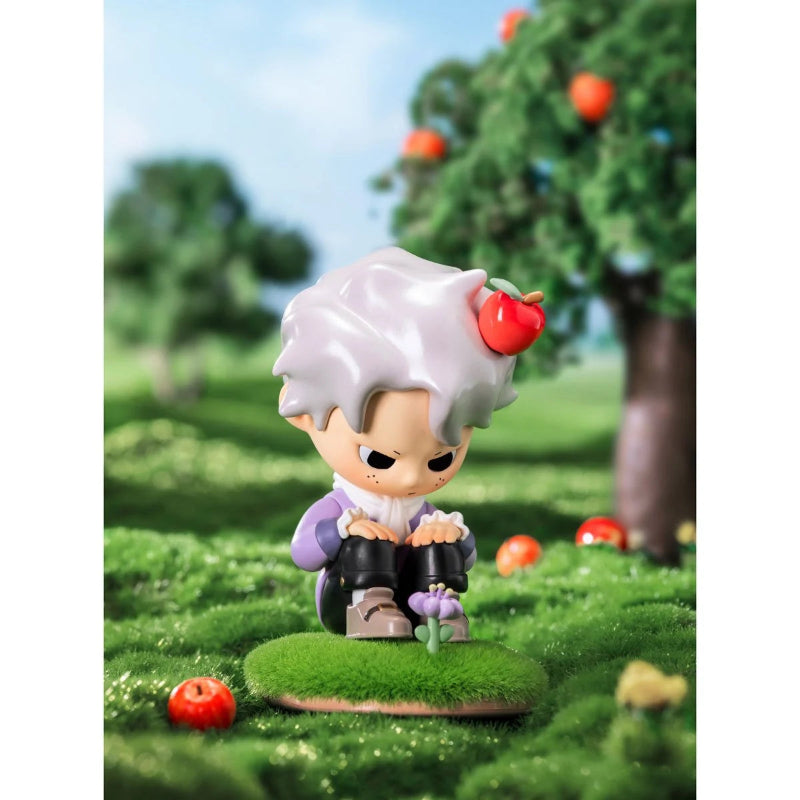 Toy figure with white hair and red apple in a grassy outdoor setting