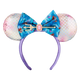 A mermaid-themed mouse ear headband featuring iridescent pink and white mermaid-scale ears, a large blue floral bow with a trident and pink gem accent, and a purple headband.