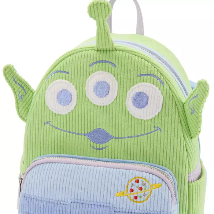 Green alien-shaped backpack with a smiley face on a white background
