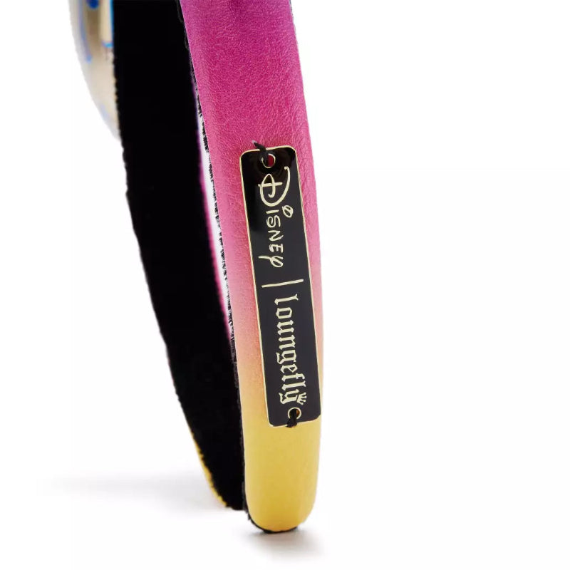 A close-up of a Disney Loungely shoe heel featuring a vibrant magenta pink upper, a black suede-like side panel, and a metallic gold toe cap, with a black brand tag attached.