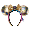 A Disney Minnie Mouse ears headband featuring gold sequined ears with holographic and blue monogram patterns, a large gold sequined bow with a central round button, and a black-to-pink gradient headband.