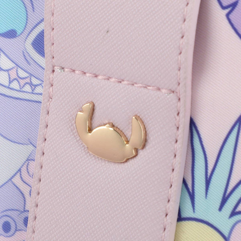 Close-up of a pink textured surface with a gold crab emblem and colorful background