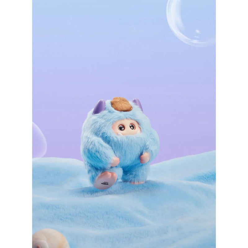 Blue plush toy with a round head and small ears on a soft blue background