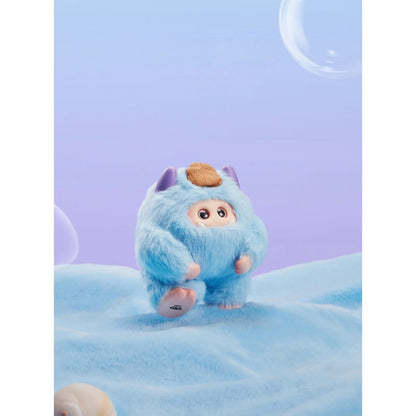 Blue plush toy with a round head and small ears on a soft blue background