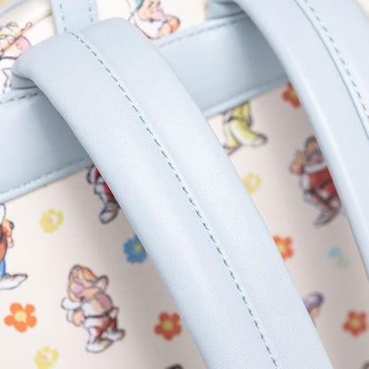 Close-up of a light blue faux leather strap with white stitching over a cream-colored fabric body printed with colorful cartoon characters and small flowers.