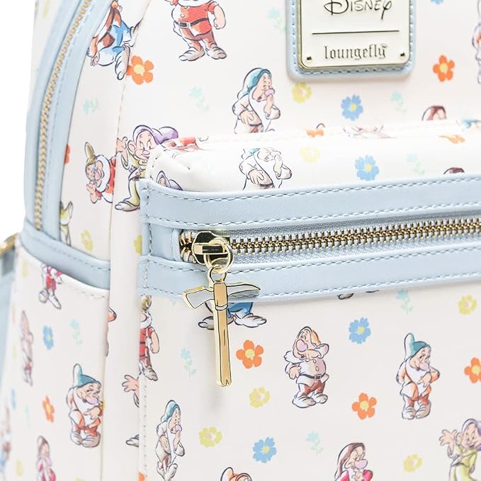 Close-up of a Disney Loungefly backpack featuring an allover print of Snow White's dwarves on a white background with light blue trim and gold zippers.