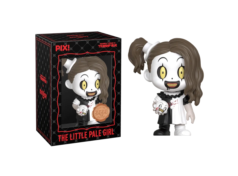 PIX! The Little Pale Girl vinyl figure with brown pigtails, clown face makeup and a small clown head in hand, next to her black window box.