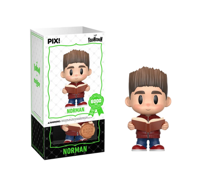 PIX! Norman vinyl figure in a red jacket and jeans holding an open book, shown beside its box with the white outer sleeve partly lifted.