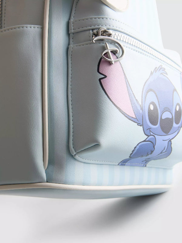 Close-up of a light blue faux-leather bag featuring a cartoon character print on the front pocket and a silver zipper pull.