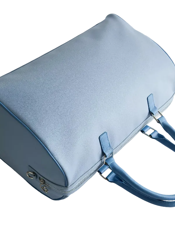A light blue leather handbag with matching blue handles and silver-tone hardware, photographed on a clean light gray background.