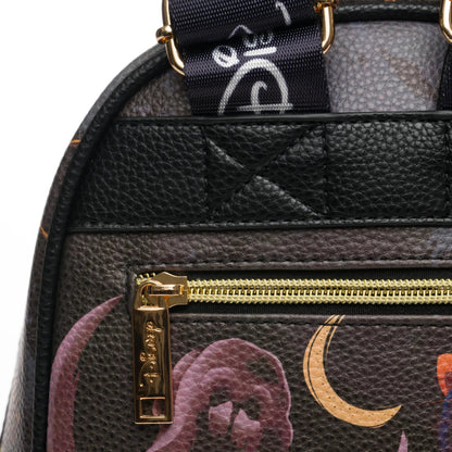 Close-up of a black textured bag with gold zipper and decorative elements on a white background