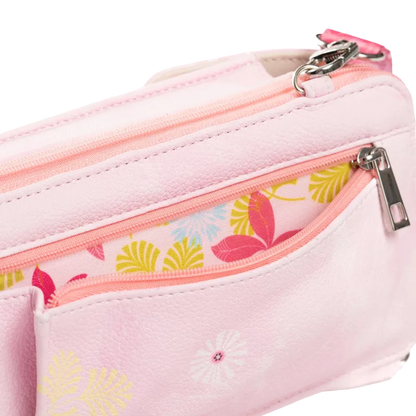 A close-up of a light pink faux-leather pouch with multiple zippered compartments. One compartment features a coral pink zipper and a colorful tropical leaf pattern lining, while the main body has a subtle white floral print.