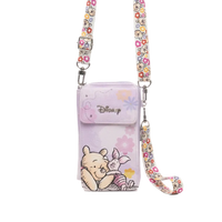 A Disney crossbody phone pouch in light purple, featuring Winnie the Pooh and Piglet illustrations, with a floral patterned strap and silver-tone hardware.