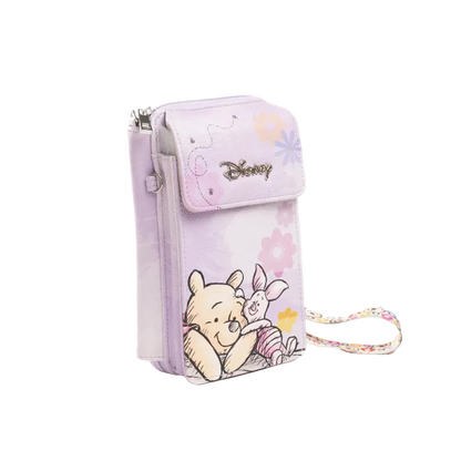 A light purple Disney crossbody phone pouch featuring Winnie the Pooh and Piglet illustrations, with a matching floral wrist strap, shown on a white background.