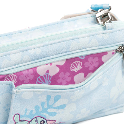 A close-up of a light blue zippered pouch with a seashell and coral pattern, showing a pink interior lining with white seashell motifs.