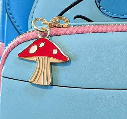 Mushroom-shaped keychain on a blue bag with pink zipper