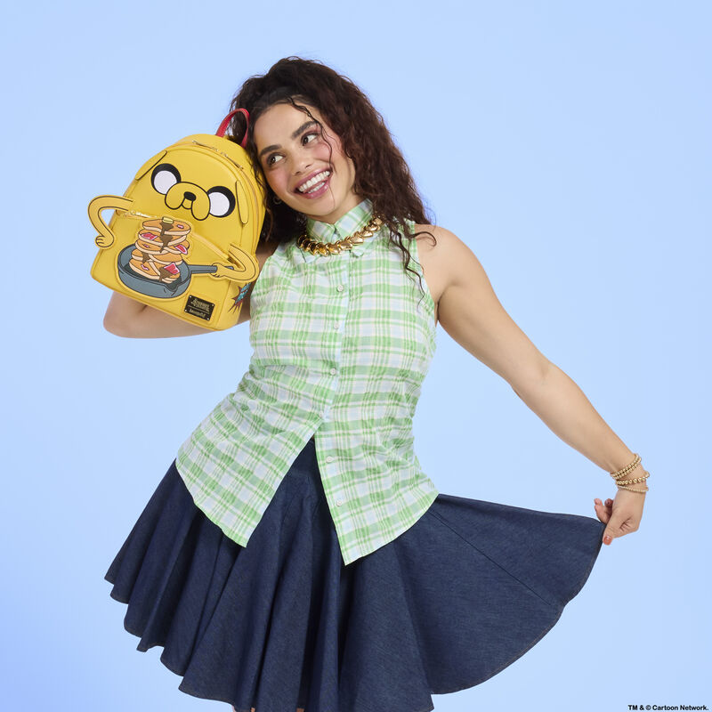Woman holding a yellow backpack with cartoon design against a light blue background