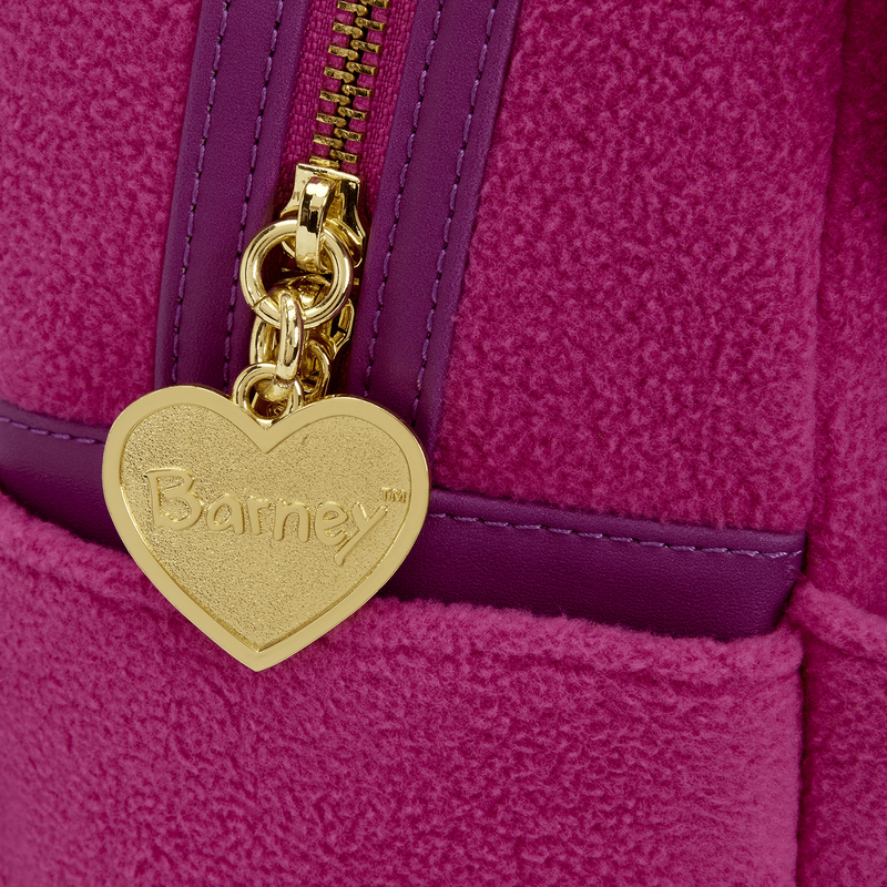 Gold heart-shaped tag with 'Barney' branding on a purple textured surface