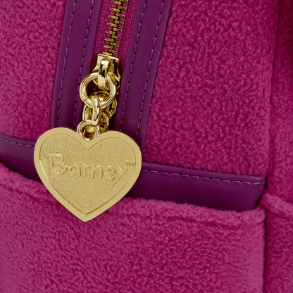 Gold heart-shaped tag with 'Barney' branding on a purple textured surface