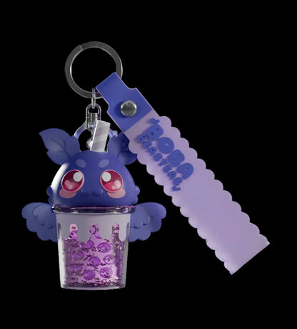 Purple character keychain with a clear container filled with purple beads on a light gray background