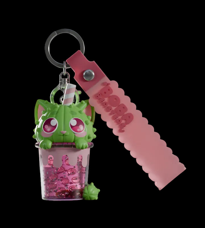 Keychain with green character and pink beads on a white background