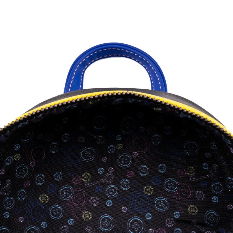 Close-up of a black backpack with colorful button pattern on a white background
