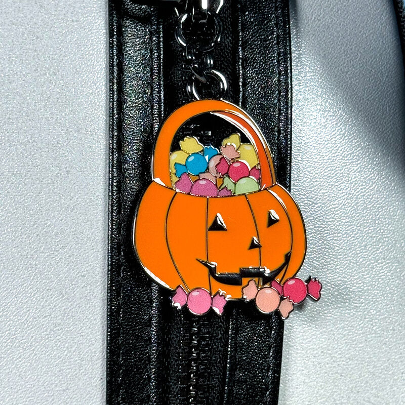 Pumpkin keychain with cartoon characters inside a basket on a black background