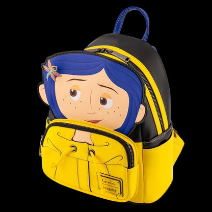 A small backpack featuring a cartoon character design with blue hair and freckles, shown on a plain white background. The backpack is primarily yellow and black with a blue top handle.