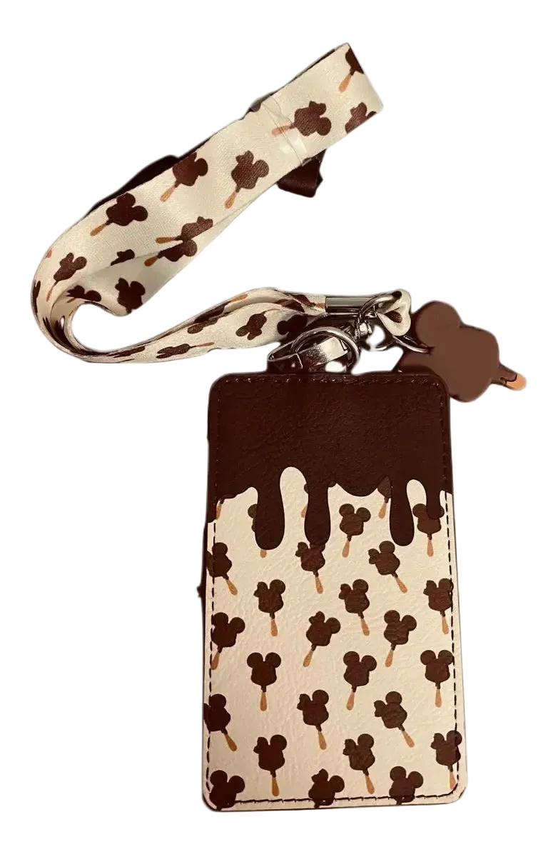 A chocolate-drip style phone pouch with a matching wrist strap, featuring a cream background with brown Mickey Mouse head and Mickey Mouse ice cream cone patterns, and a solid dark brown top section.