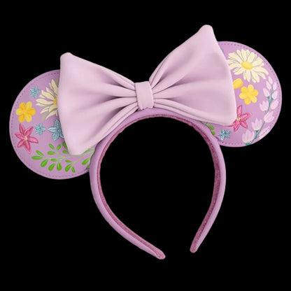 Pink mouse ears with a large bow and floral designs on a white background