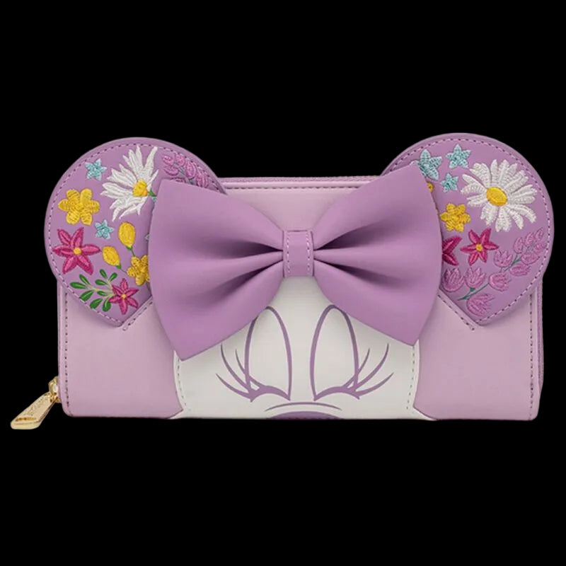 A lavender and white wallet styled like Minnie Mouse's head, featuring a large lavender bow on the front, floral embroidery on the mouse ears, and a gold zipper pull on a white background.
