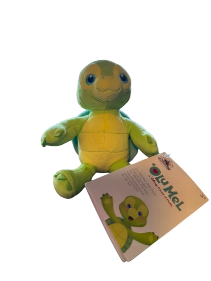Green plush turtle toy with a matching packaging on a white background