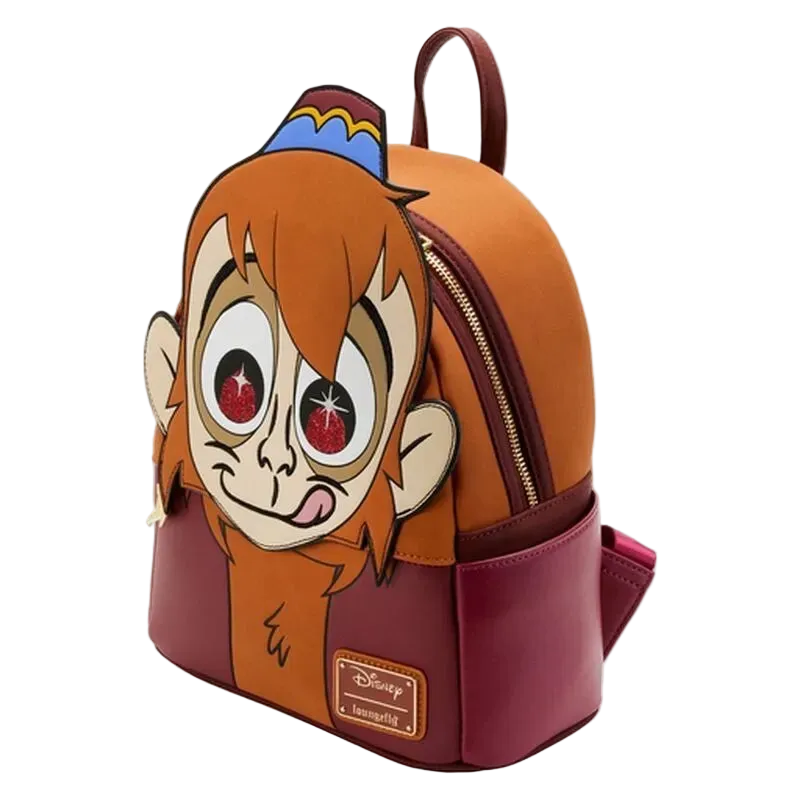 A Disney Aladdin character backpack featuring a large 3D monkey face on the front, with an orange top section, burgundy bottom section, and a blue and yellow hat detail on top.