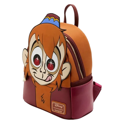 A Disney Aladdin character backpack featuring a large 3D monkey face on the front, with an orange top section, burgundy bottom section, and a blue and yellow hat detail on top.