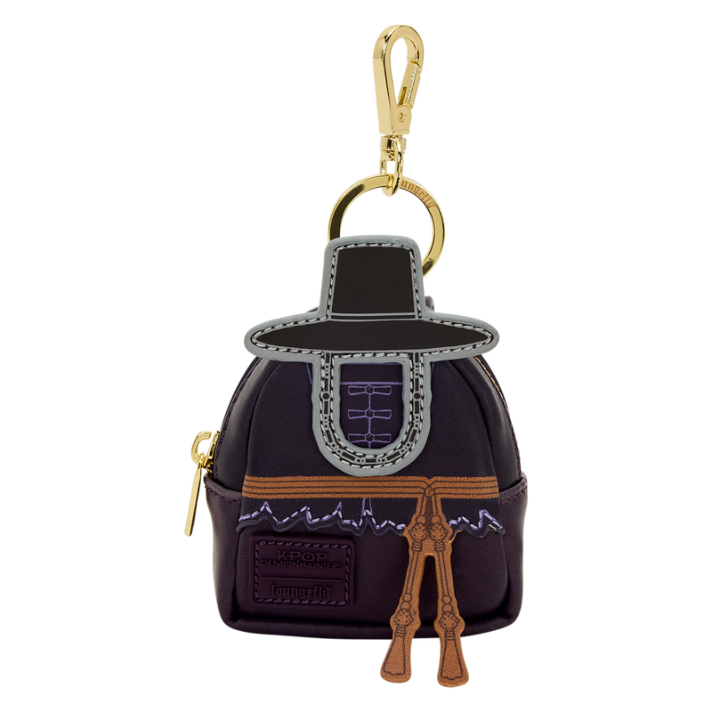 Keychain shaped like a character in a dark outfit with gold accents on a white background