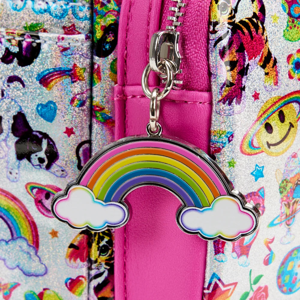 A close-up of a bright pink zipper pull charm shaped like a rainbow with white clouds on either side, attached to a silver zipper. The charm is shown against a colorful patterned fabric background with glitter, smiley faces, and rainbow motifs.
