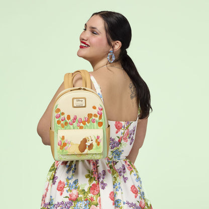 Woman wearing a floral dress with a backpack featuring a cartoon character on a light green background