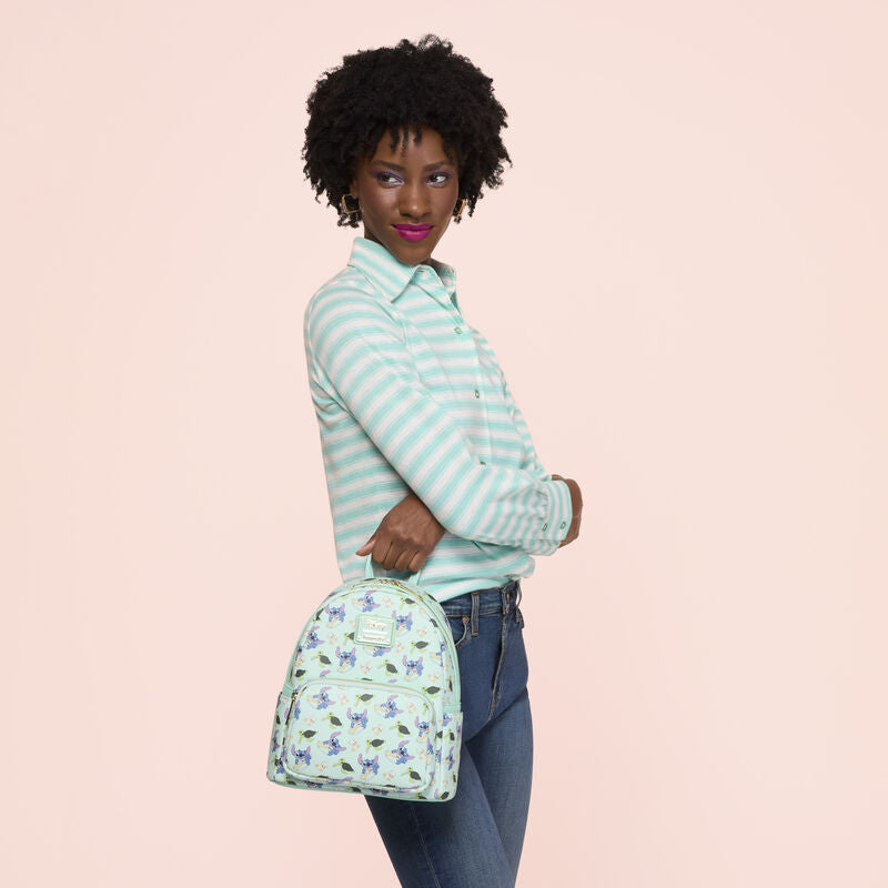 Woman holding a patterned bag against a pink background