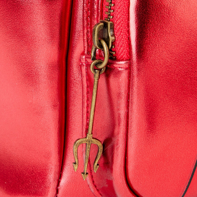 Close-up of a red leather bag with a gold trident-shaped zipper pull.